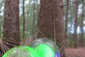 Handblown glass orbs in the forest, pond, and on the shore